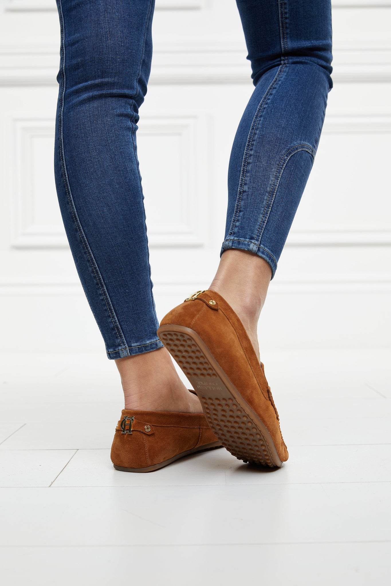 classic tan suede loafers with a leather sole and top stitching details and gold hardware paired with denim skinny jeans