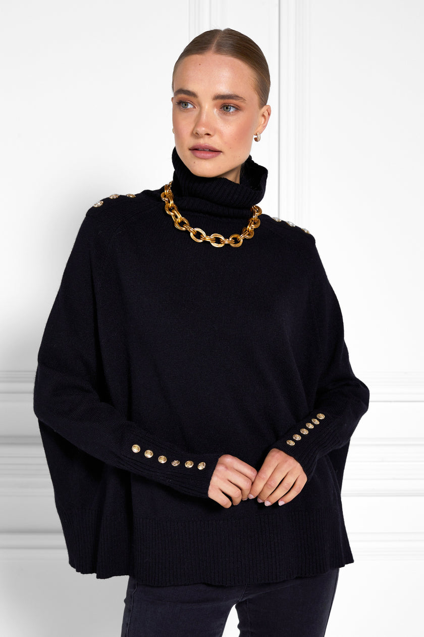 womens funnel neck batwing shaped cape in black knit with split side detail and ribbed neckline cuffs and hem