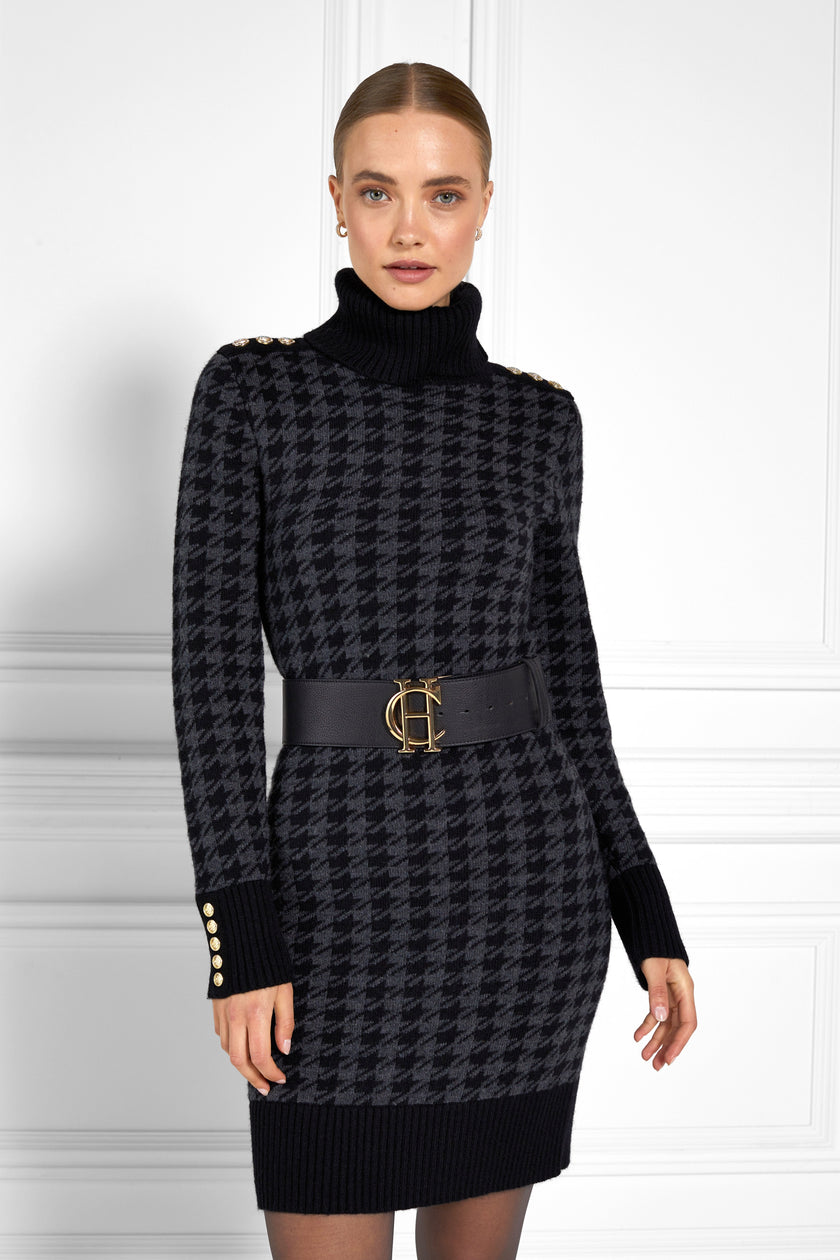 womens black and dark grey houndstooth roll neck jumper dress with contrast black cuffs and ribbed hem with gold button detail on the cuffs and shoulders worn with wide black belt