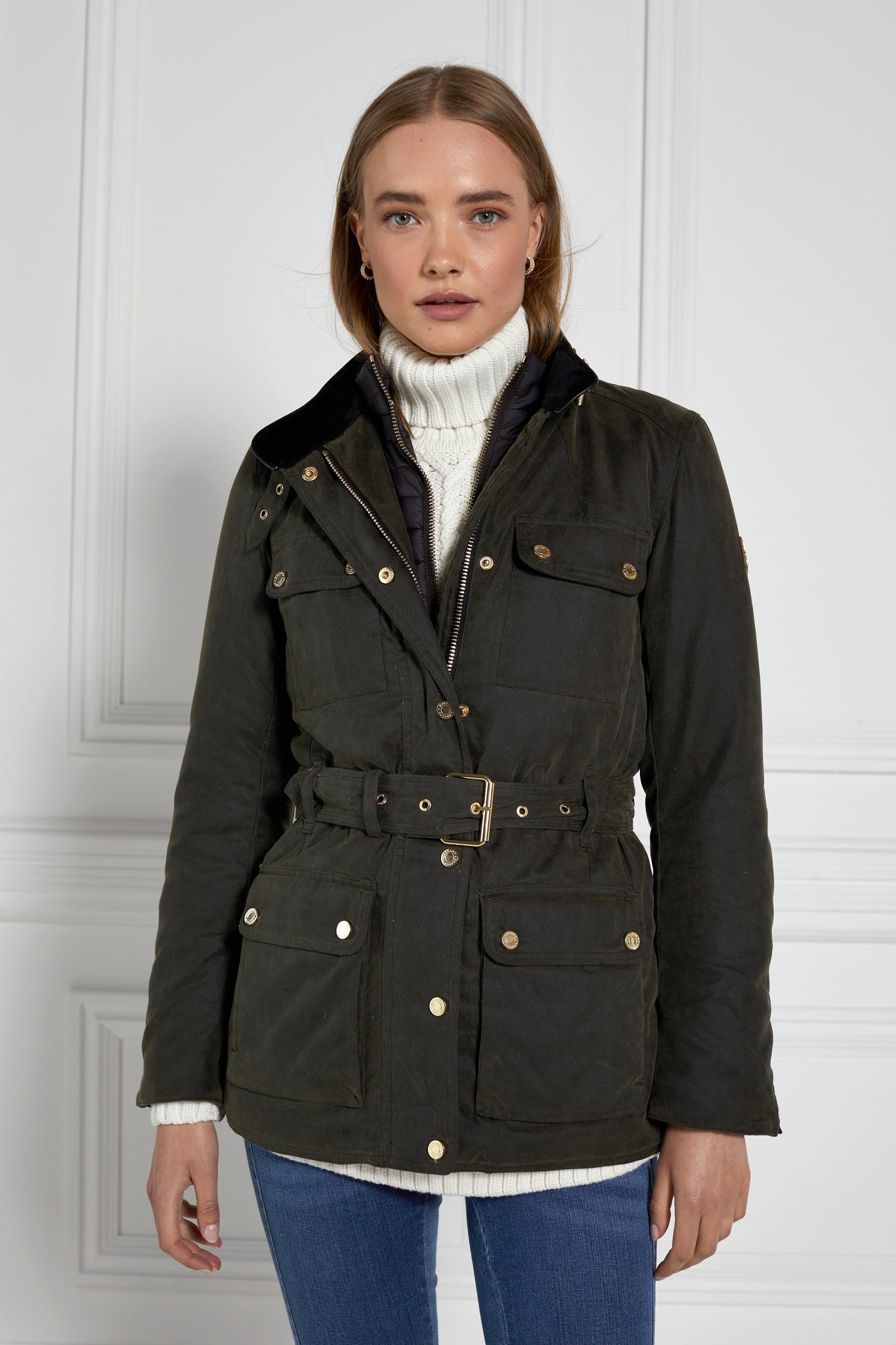 womens coated wax jacket in dark olive green with four patch pockets belted waist and internal black gilet 