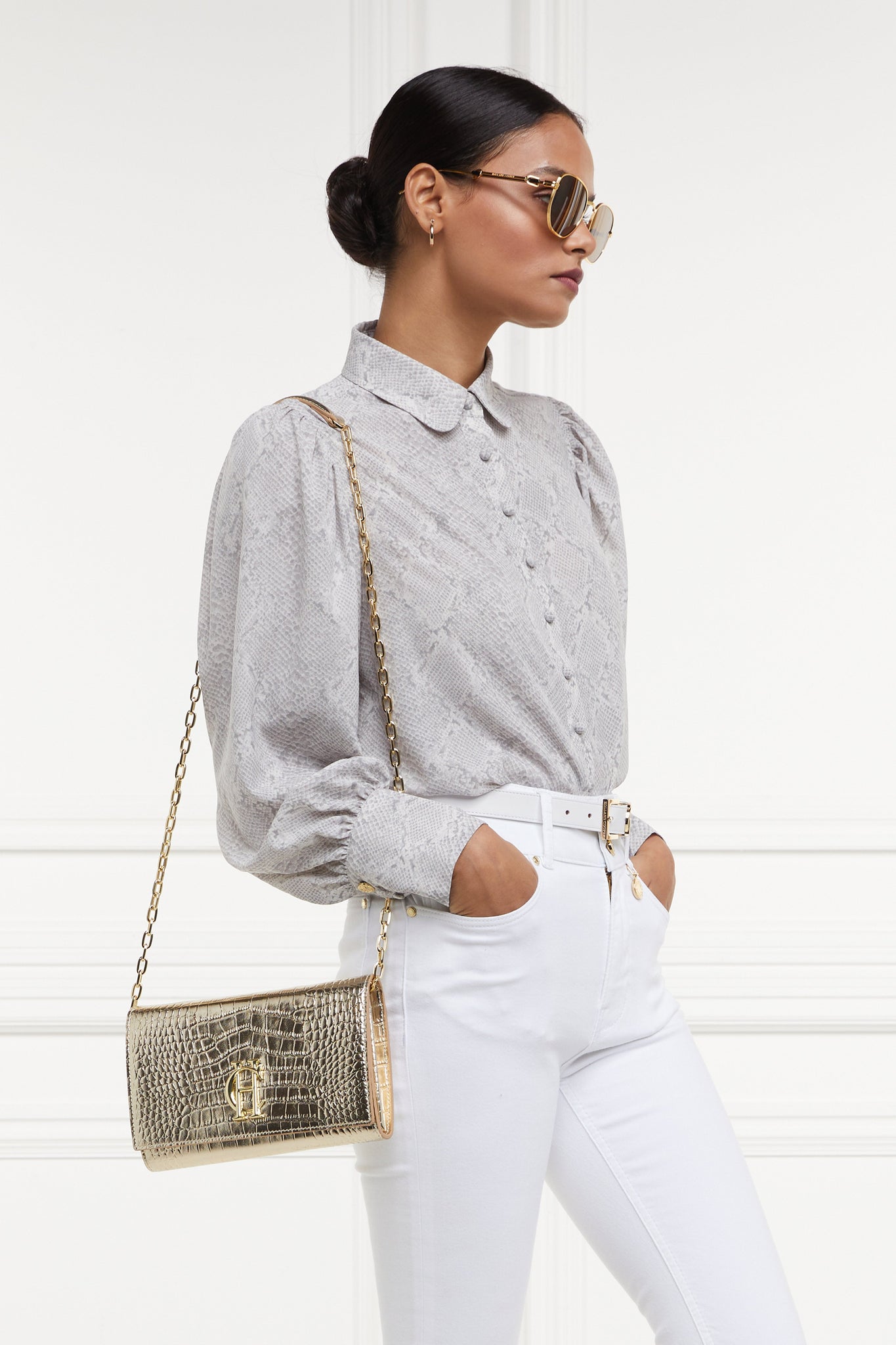 womens snake print shirt with white jeans and gold croc embossed leather bag with gold chain over shoulder