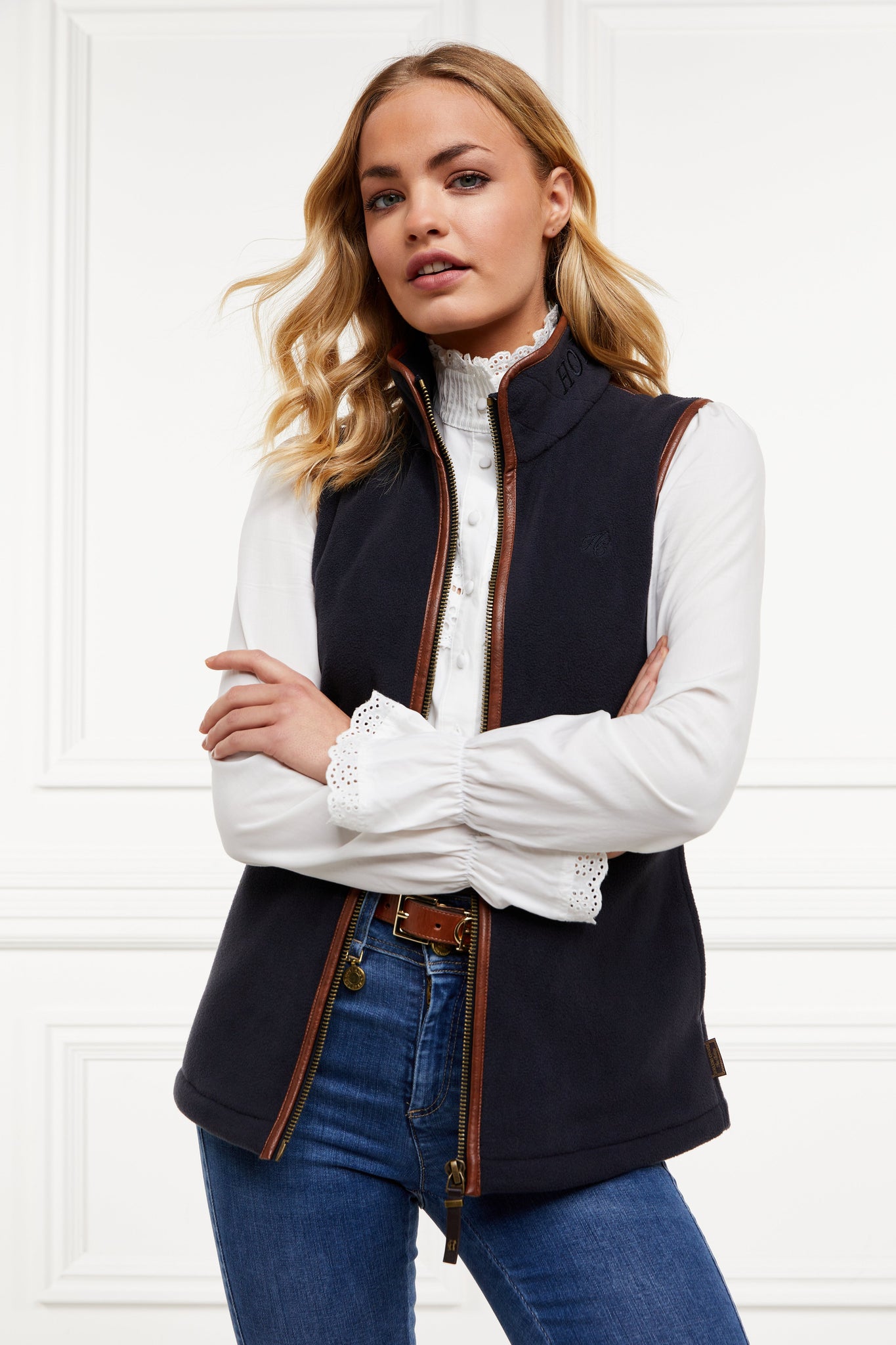 womens fleece gilet in navy with dark brown leather piping around armholes neckline and down the front zip fastening worn with a white shirt