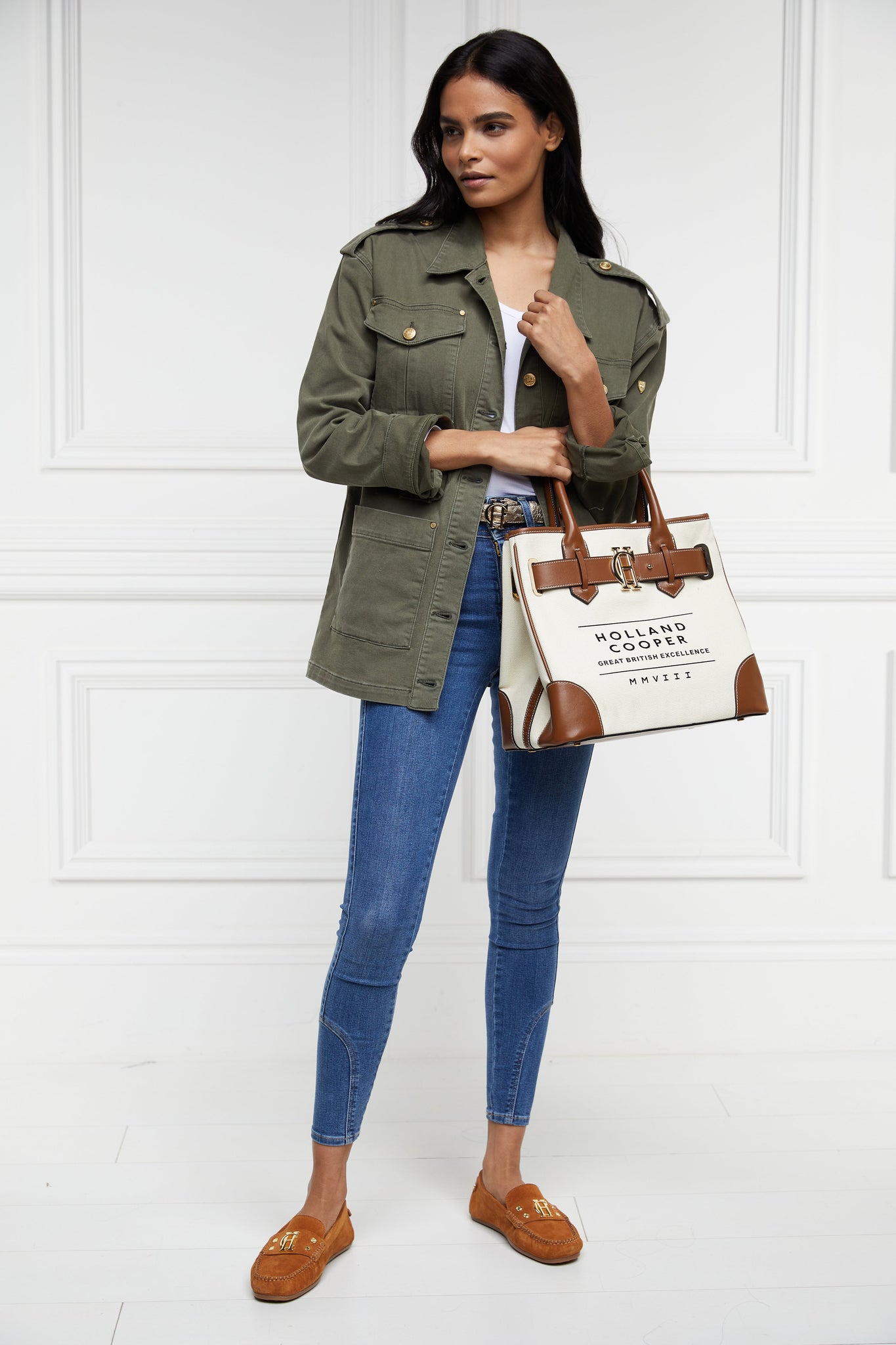 khaki green cotton womens shacket with blue denim jeans and cotton canvas womens tote bag with tan leather trims and handles with gold hardware and detachable keychain