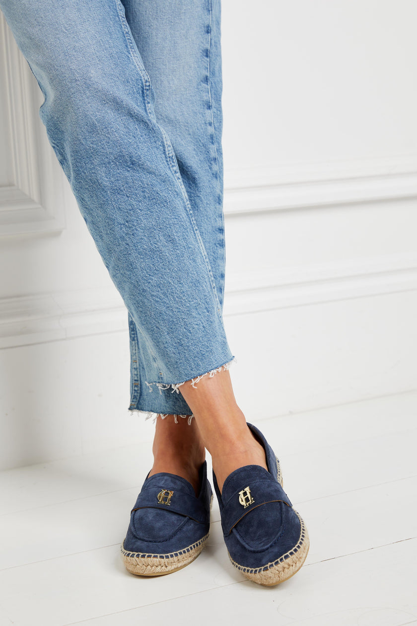 Blue suede espadrille with a natural straw sole and gold hardware on top paired with denim straight jeans with frayed hems