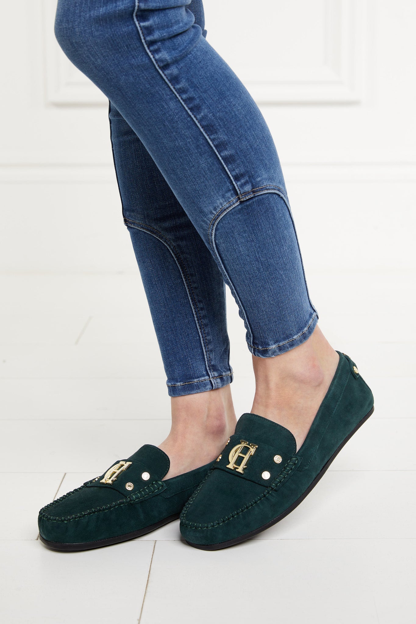 classic emerald green suede loafers with a leather sole and top stitching details and gold hardware paired with a classic denim skinny jean