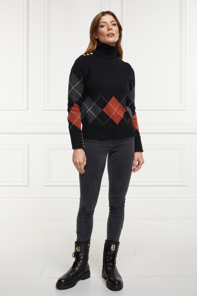 a classic roll neck black argyle jumper with grey and red diamonds and gold button detail on the cuffs and collar