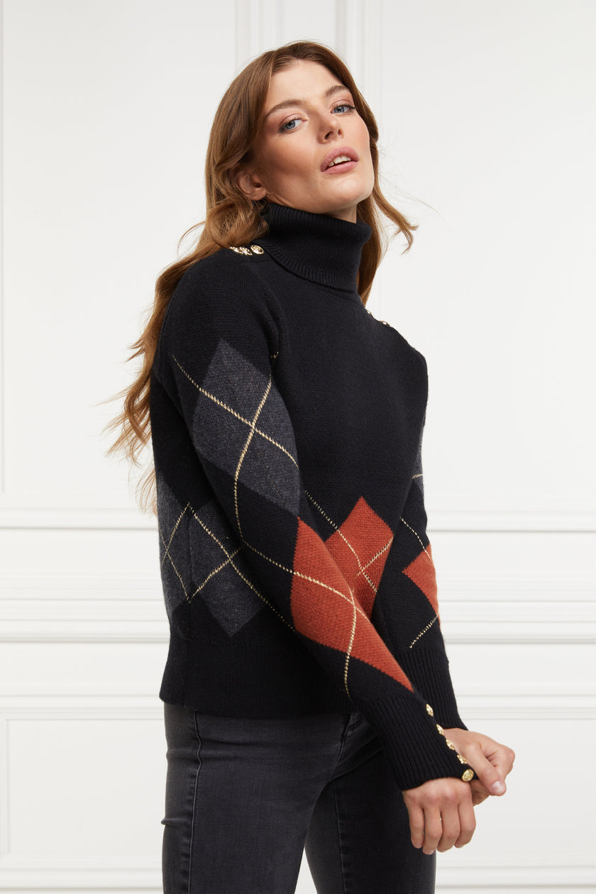 a classic roll neck black argyle jumper with grey and red diamonds and gold button detail on the cuffs and collar