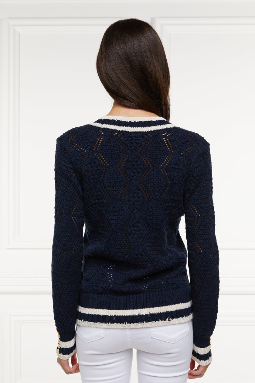 back of a cricket style v neck lightweight knit in navy with thick ribbed  cream double stripe trims on cuffs and neckline