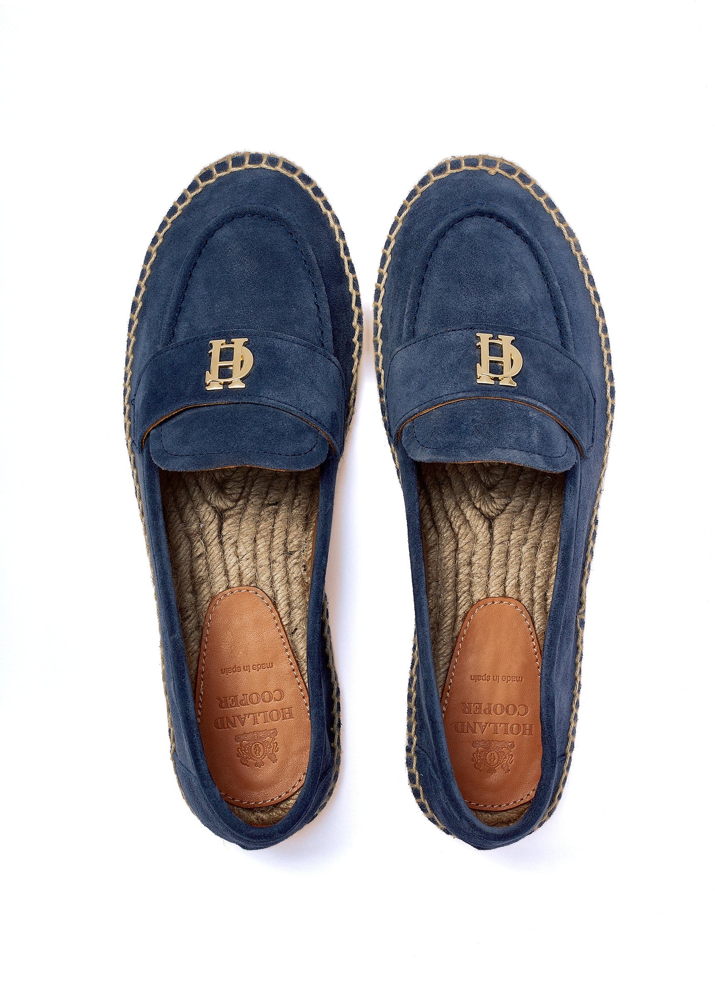 Birds eye view of Blue suede espadrille with a natural straw sole and gold hardware on top and a branded leather patch on the sole of the heel