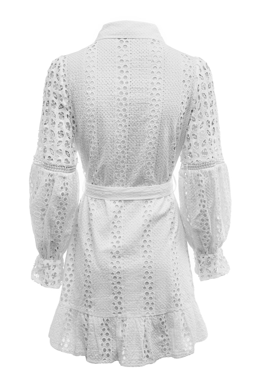 Back shot of womens white mini dress in broderie lace with a tie around waist with natural raffia bag