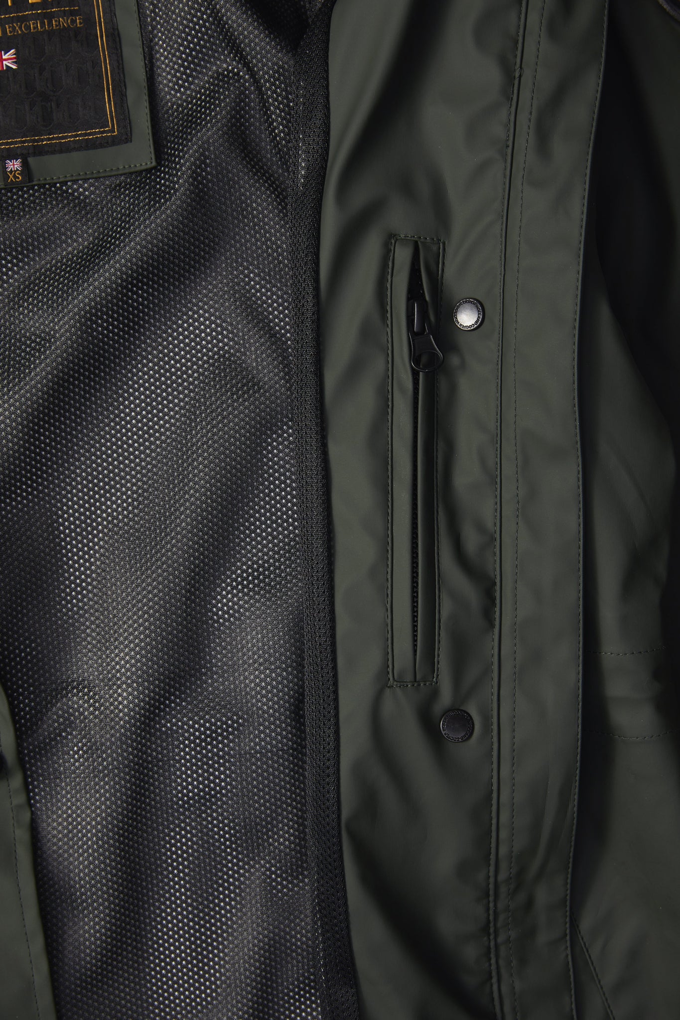 detail of womens green hooded rain coat with black hardware 