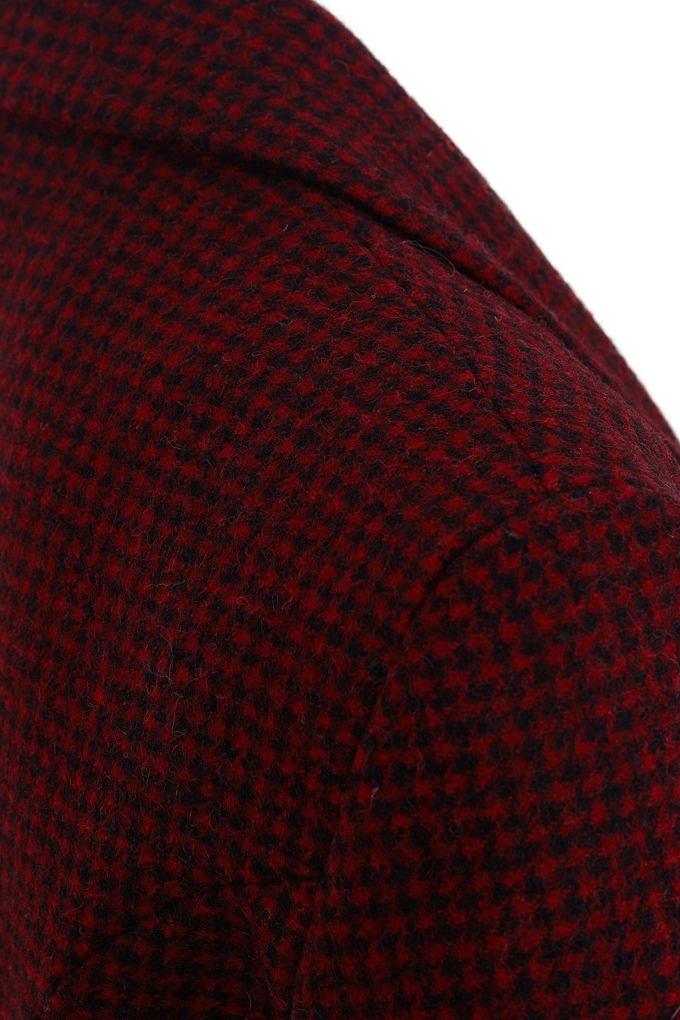 shoulder seam of double breasted wool blazer in deep red houndstooth with two hip pockets and gold button detials down front and on cuffs and handmade in the uk