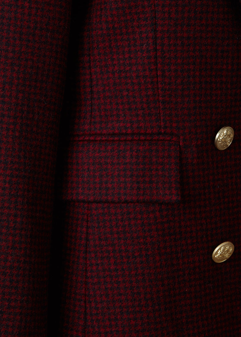 pocket detail on double breasted wool blazer in deep red houndstooth with two hip pockets and gold button detials down front and on cuffs and handmade in the uk