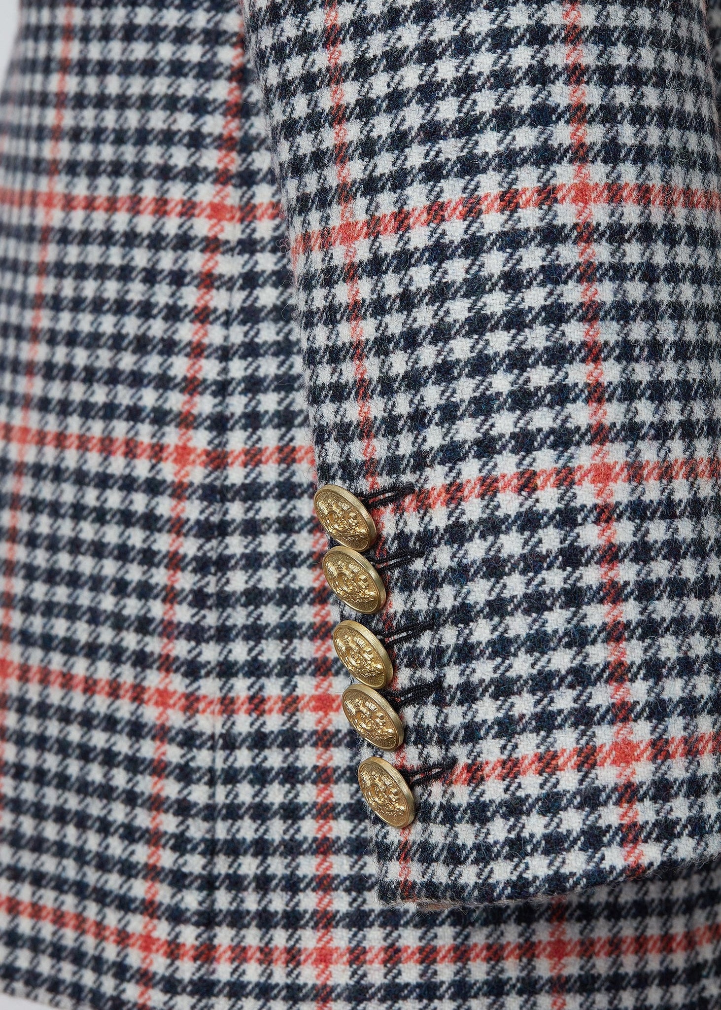 gold button detail on cuffs of double breasted wool blazer in black white and pink check with two hip pockets and gold button details down front and on cuffs and handmade in the uk