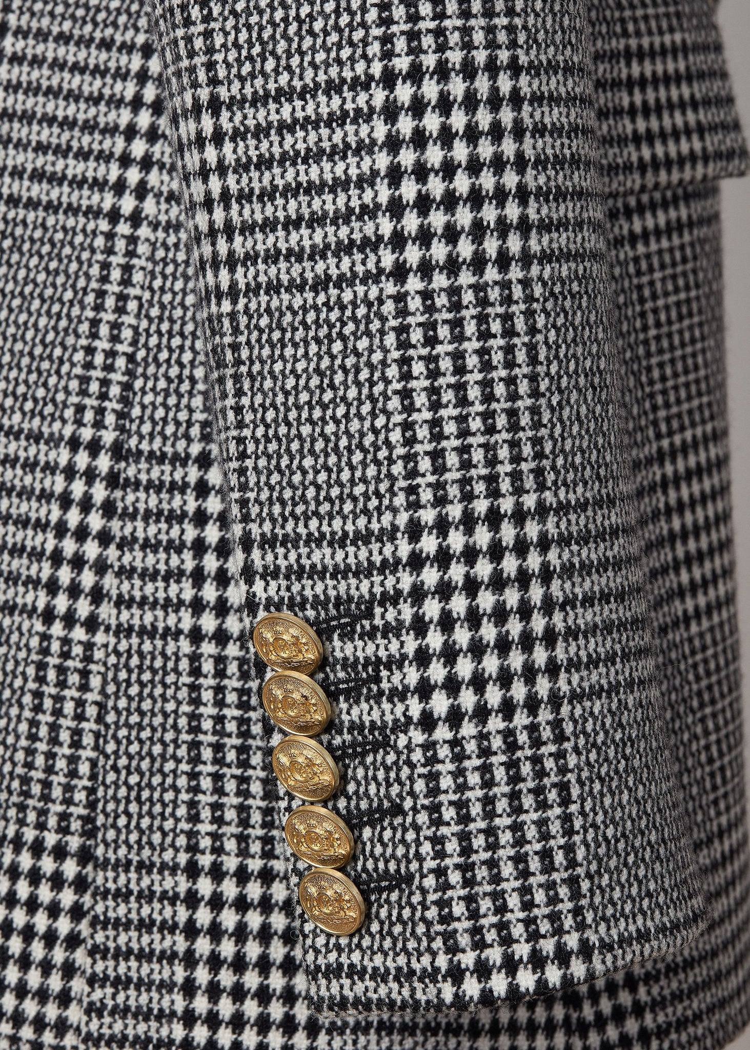 gold button detail on cuffs of double breasted wool blazer in black and white check with two hip pockets and gold button details down front and on cuffs and handmade in the uk