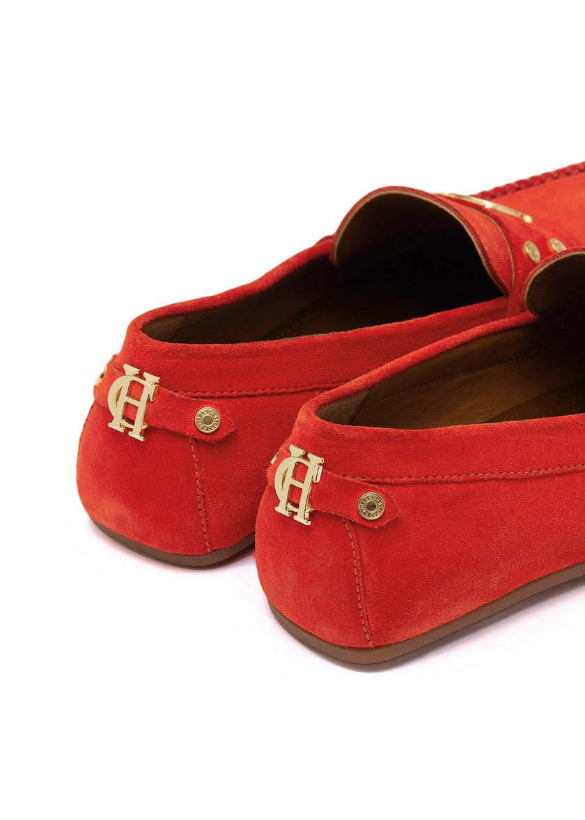 back of orange suede loafers with a leather sole and top stitching details and gold hardware