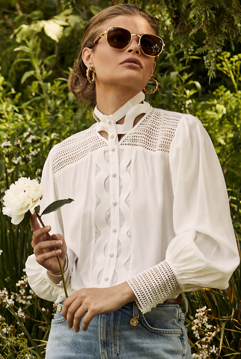 womens white polyester shirt with lace detail to the collar shoulders and arm cuffs and balloon sleeve and womens denim short