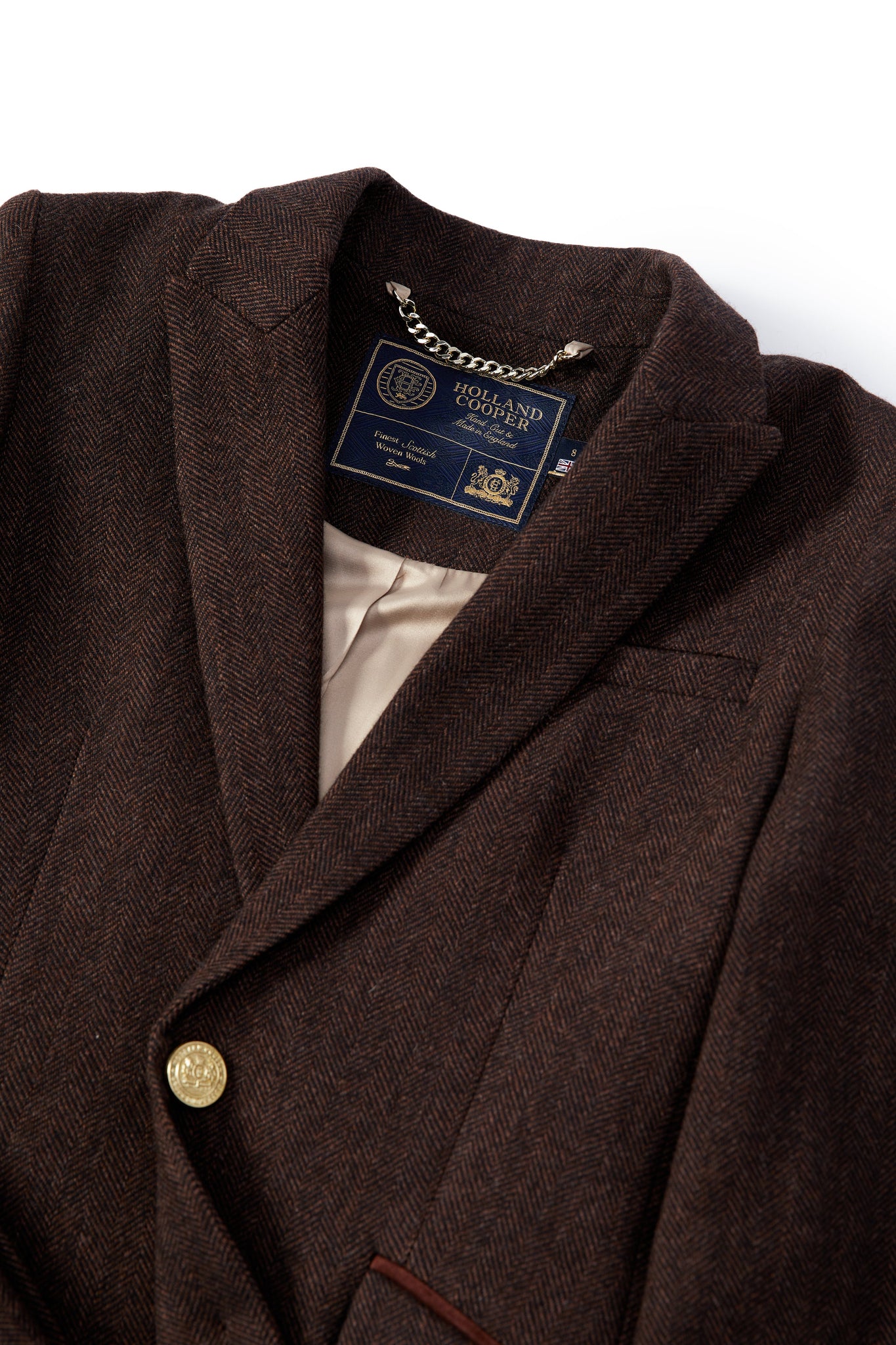 flat lay detail of womens dark brown herringbone tweed mid-length single breasted coat detailed with gold hardware