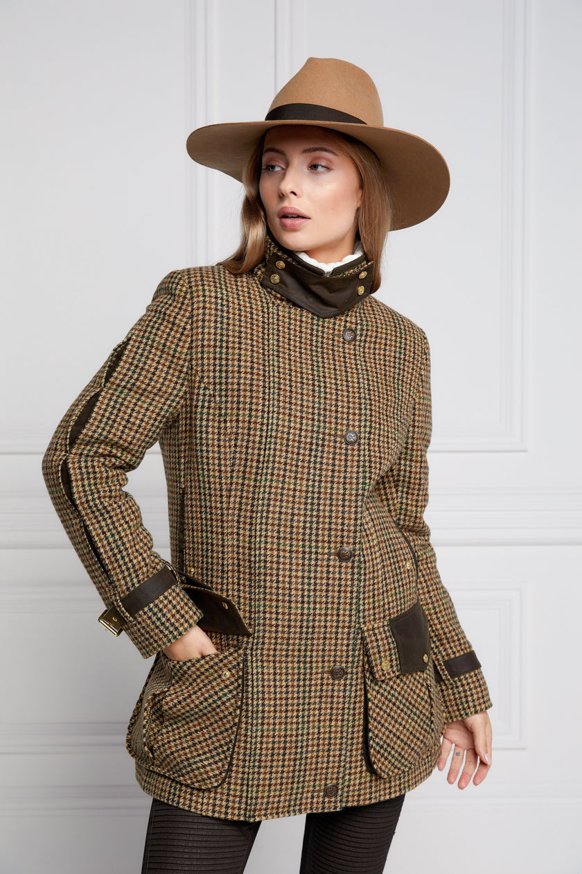 Woman in green and brown tweed field coat in brown trilby hat