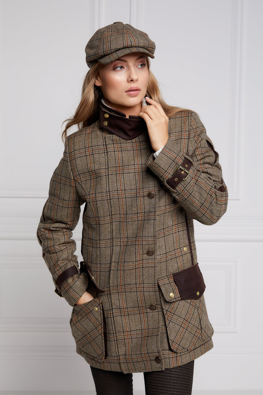 Woman in brown tartan tweed field coat and baker boy cap