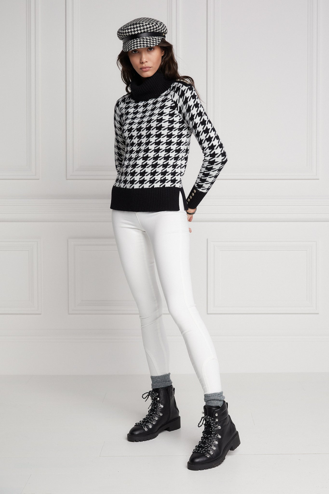 a classic black and white houndstooth jumper with contrast black cuffs, roll neck and split ribbed hem with gold button detail on the cuffs and collar