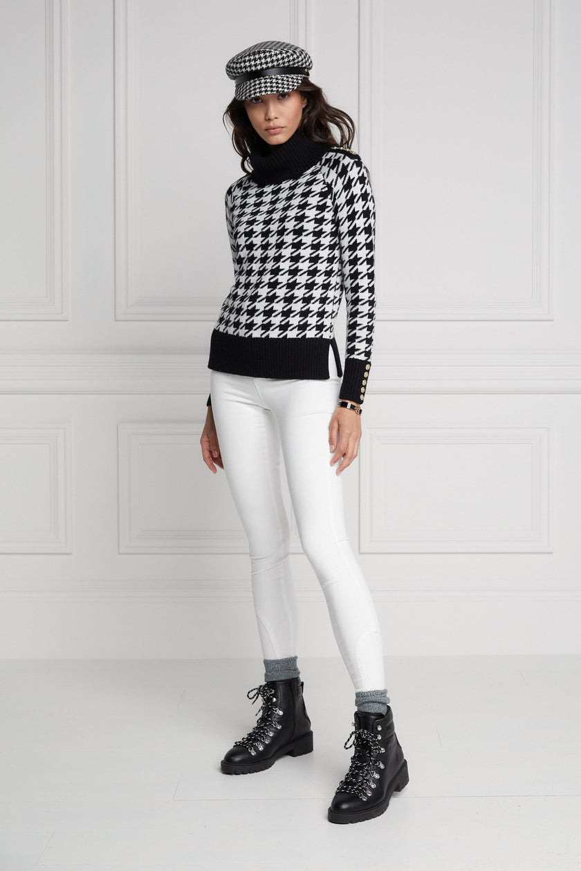 a classic black and white houndstooth jumper with contrast black cuffs, roll neck and split ribbed hem with gold button detail on the cuffs and collar