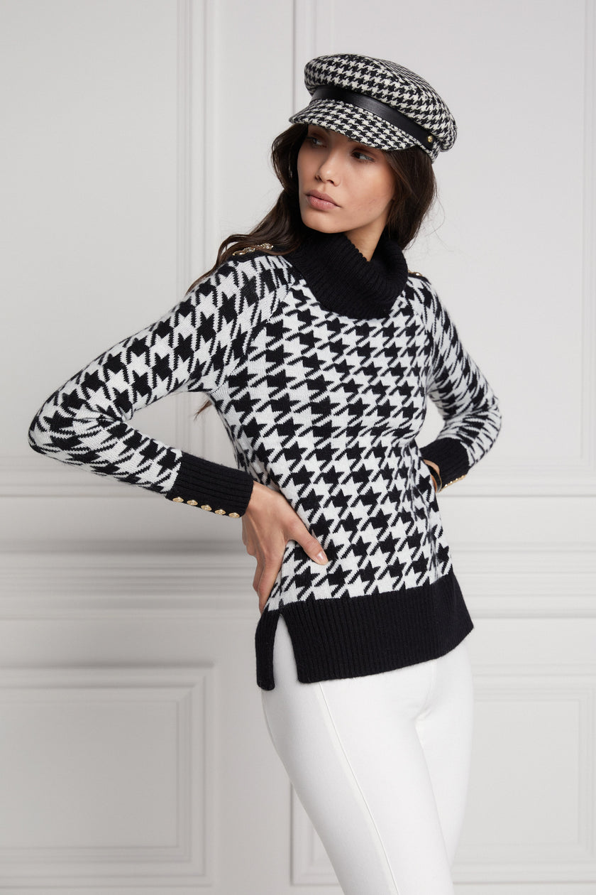 a classic black and white houndstooth jumper with contrast black cuffs, roll neck and split ribbed hem with gold button detail on the cuffs and collar