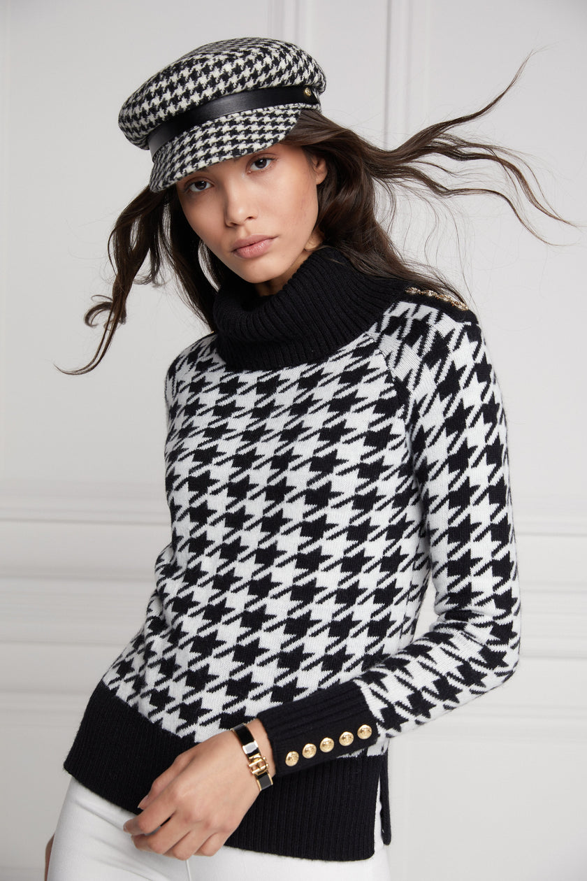 a classic black and white houndstooth jumper with contrast black cuffs, roll neck and split ribbed hem with gold button detail on the cuffs and collar