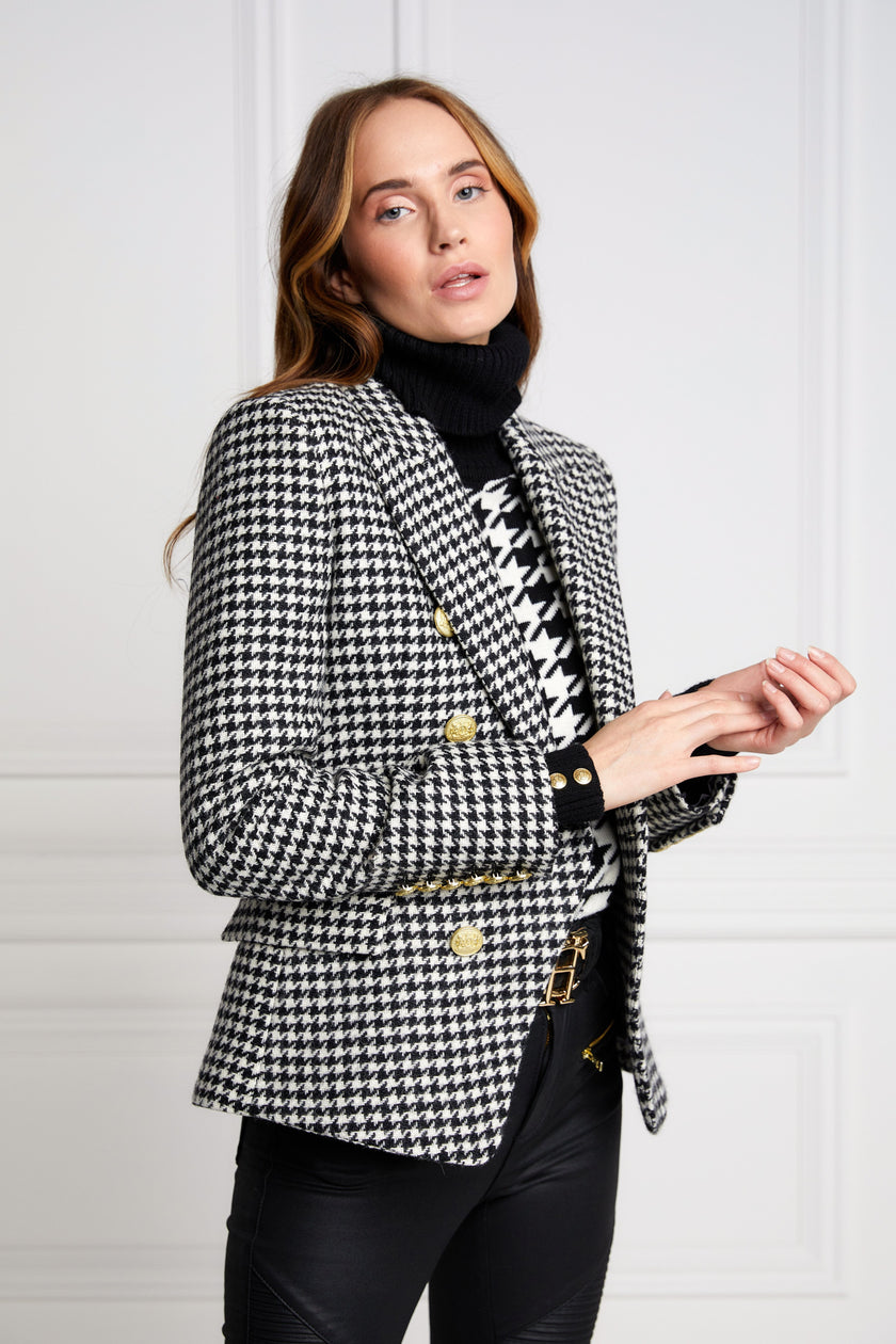 British made double breasted blazer that fastens with a single button hole to create a more form fitting silhouette with two pockets and gold button detailing this blazer in black and white houndstooth