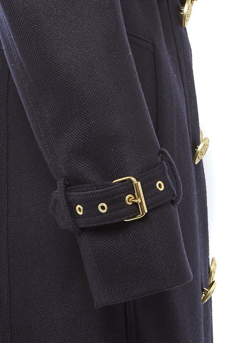 Arm detail of womens navy detailed with gold hardware knee length wool trench coat