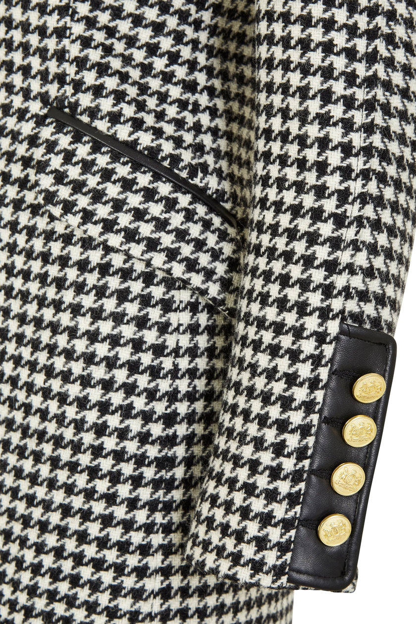 sleeve detail of white and black houndstooth tweed womens coat with gold hardware and black leather detailing