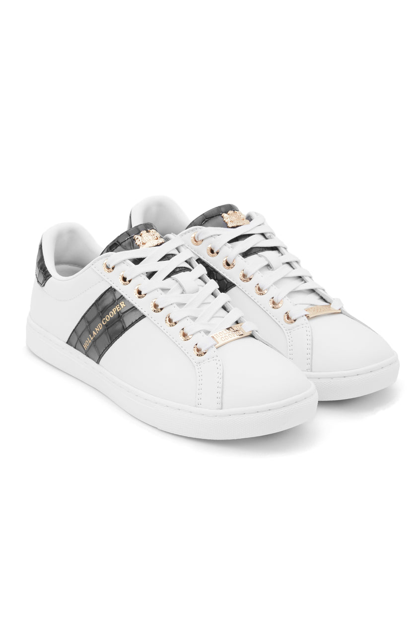 white leather trainers with white laces detailed with a diagonal stripe of black croc embossed leather on the side with gold foil branding and a black croc embossed leather tongue and heel with gold hardware