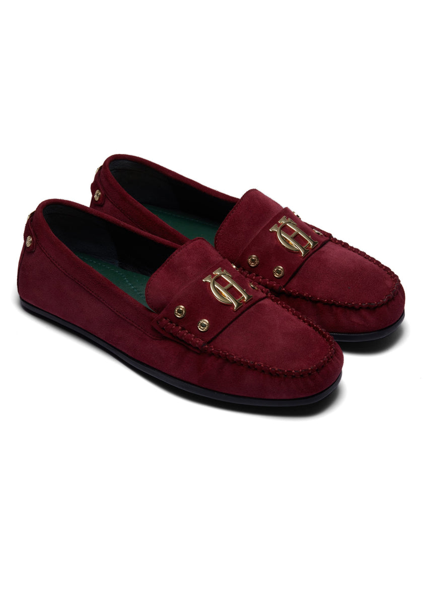 classic deep red suede loafers with a leather sole and top stitching details and gold hardware and a dark green inner sole