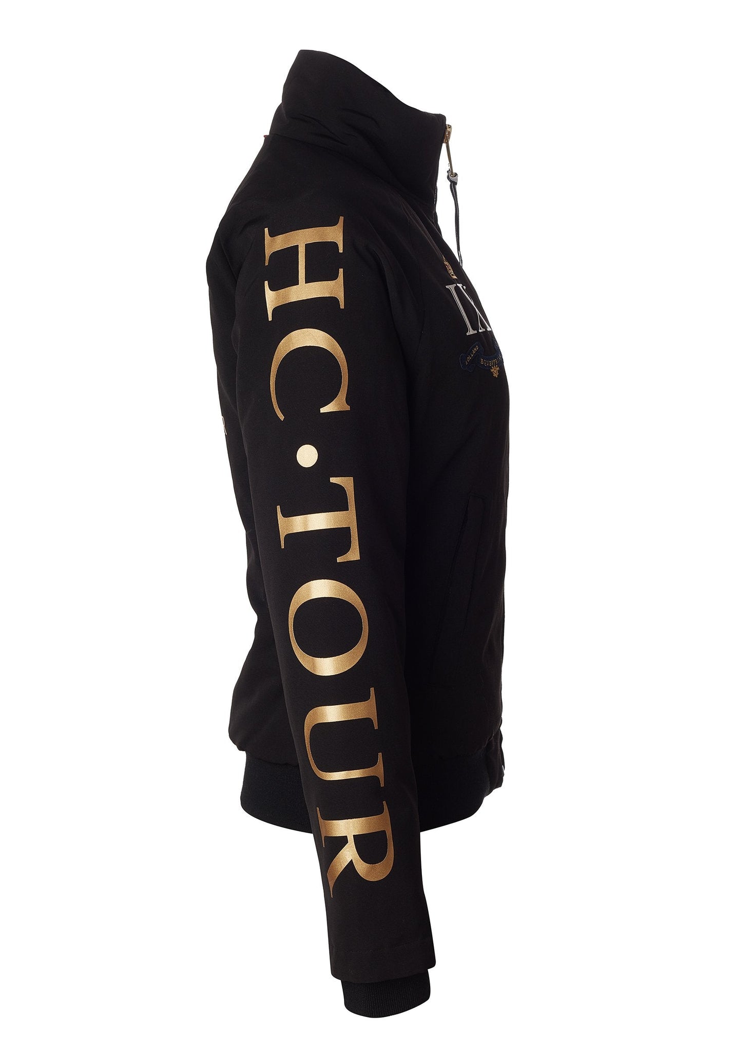 side of womens bomber style water resistant riding jacket in black lined with fleece with elasticated ribbed cuffs and hem and covered in holland cooper equestrian graphic prints showin graphic gold HC tour print down arm