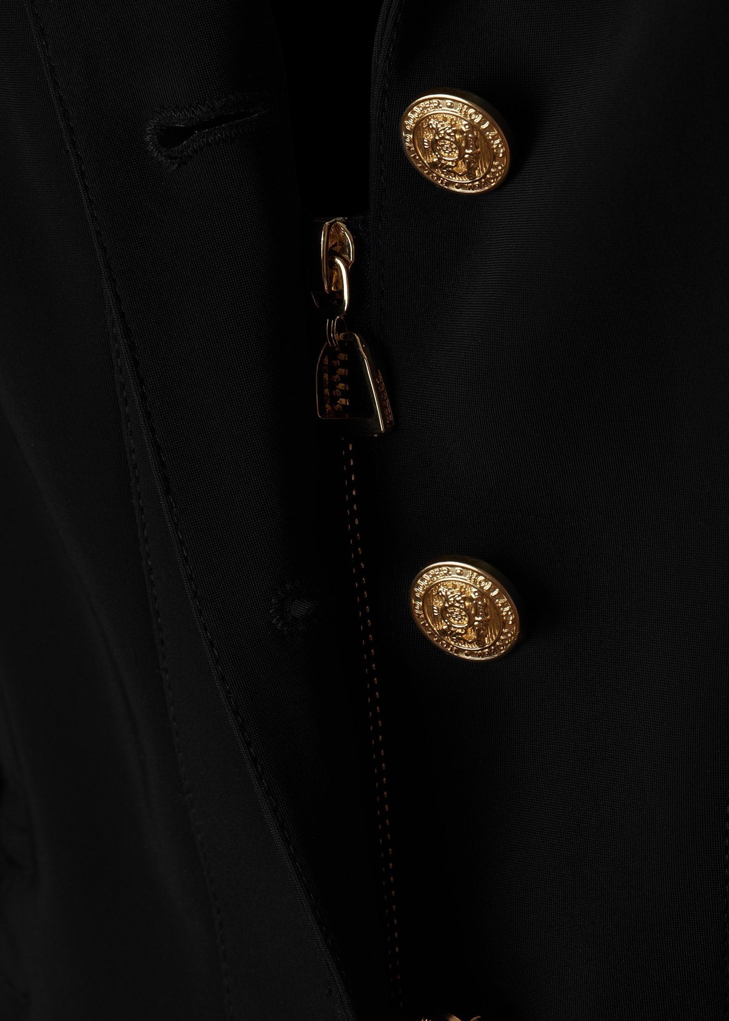 zip detail of womens black competition jacket with gold hardware 