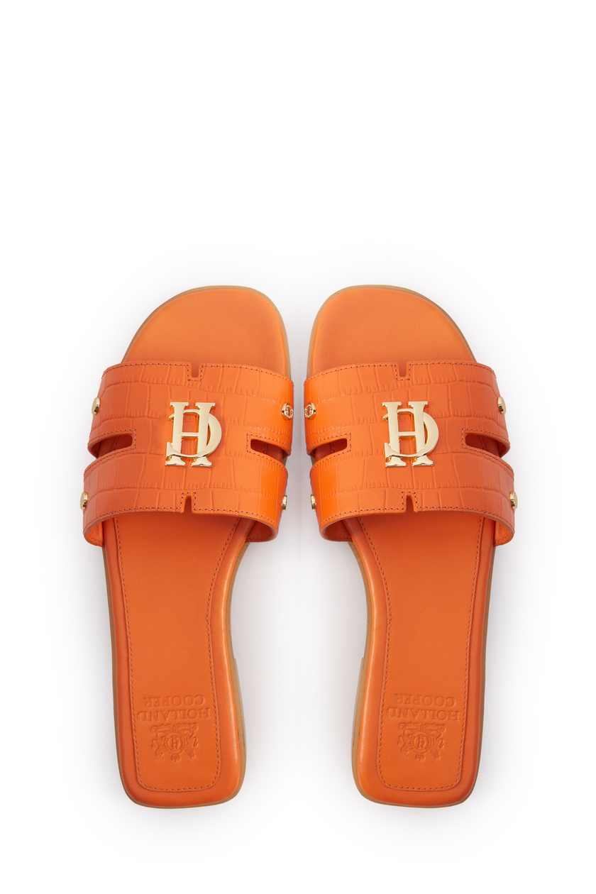 Birds eye view of orange croc embossed leather sliders with a tan leather sole and gold hardware. 