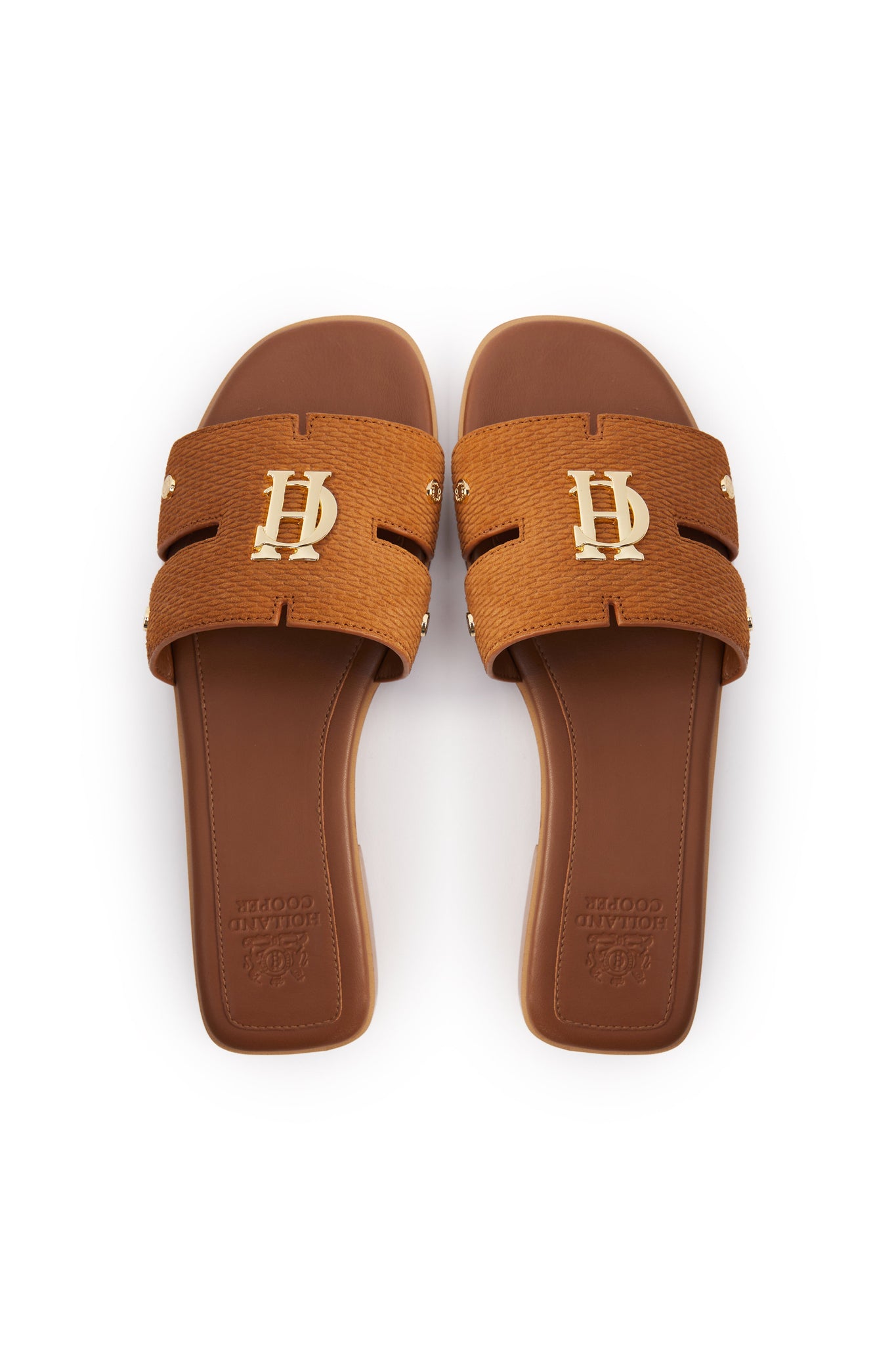 Birds eye view of tan suede sliders with a tan branded leather sole and gold hardware. 