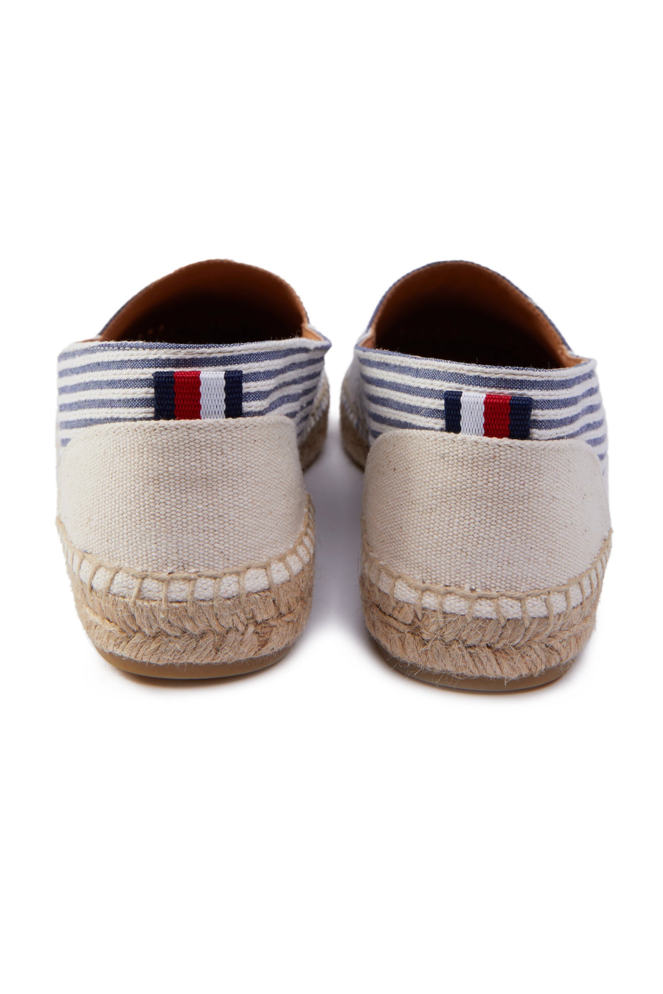 Back of classic style white and blue striped canvas espadrille with plaited jute sole and jute toe cap with red, white and blue small tag to the heel